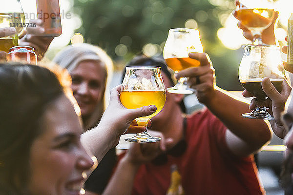 Glückliche Freunde stoßen in einer Bar auf Bier an