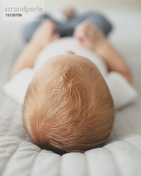 Nahaufnahme eines kleinen Jungen  der zu Hause auf dem Bett liegt