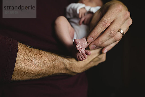 Nahaufnahme eines Vaters  der seine Tochter zu Hause trägt