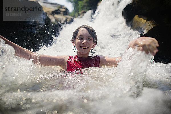 Glücklicher Junge genießt die Bua Thong Wasserfälle