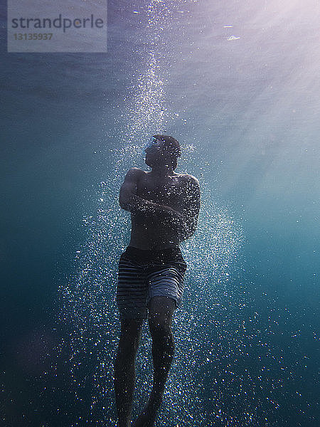 Mann schwimmt in voller Länge im Meer