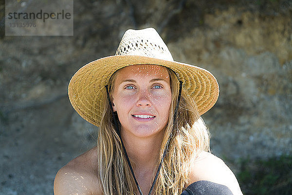 Nahaufnahme-Porträt einer Frau mit Sonnenhut am Strand