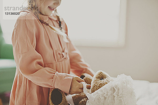 Mitschnitt eines Mädchens  das zu Hause mit einem Teddybär spielt