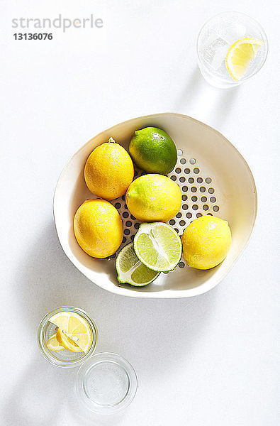 Draufsicht auf Zitronen in einem Behälter auf weißem Hintergrund