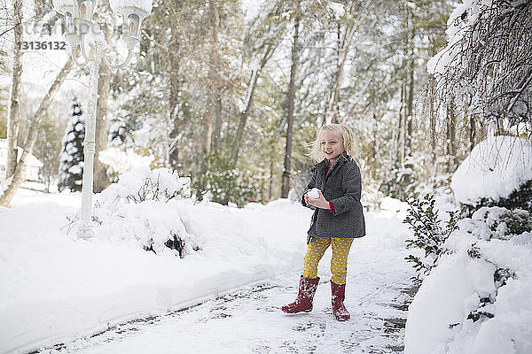 Mädchen spielt mit Schnee im Park