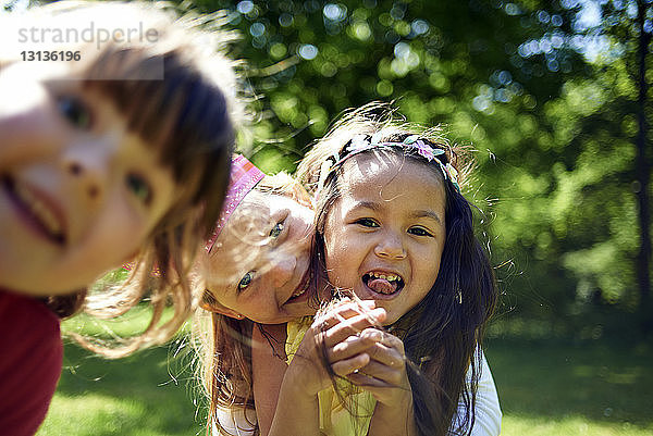 Porträt von fröhlichen Mädchen während der Geburtstagsfeier im Park