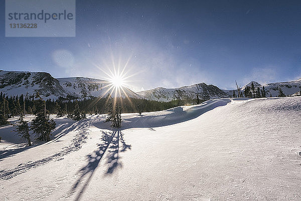 Szenische Ansicht einer schneebedeckten Landschaft gegen den Himmel bei sonnigem Wetter