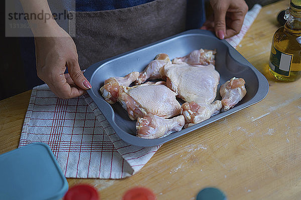 Hochwinkelansicht einer Frau  die Hühnerfleisch zubereitet  während sie in der Küche steht