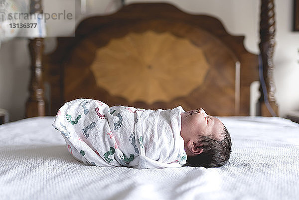 Seitenansicht eines neugeborenen Mädchens in eine Decke gewickelt