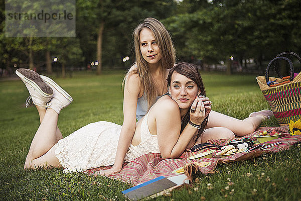 Lesbisches Paar entspannt sich auf Grasfeld im Park