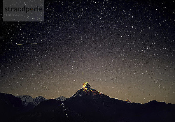 Landschaftliche Ansicht des Machapuchare-Gebirges gegen das nächtliche Sternenfeld