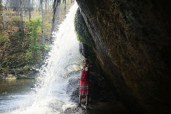 Junge in voller Länge an den Bua-Tang-Wasserfällen stehend