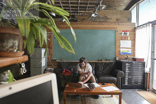 Schreiner mit Laptop-Computer in der Werkstatt