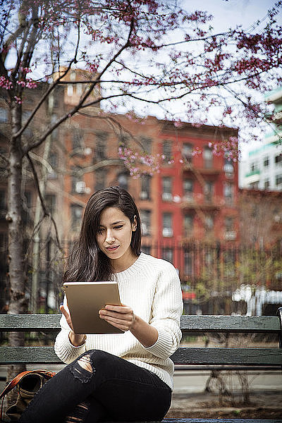 Junge Frau benutzt Tablet-Computer in der Stadt