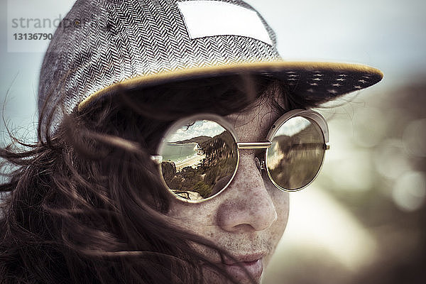 Nahaufnahme einer Frau mit Sonnenbrille gegen den Himmel