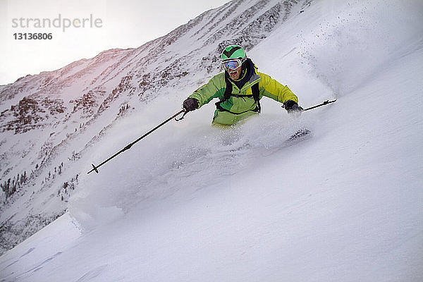 Glücklicher Mann beim Skifahren auf der Schneepiste