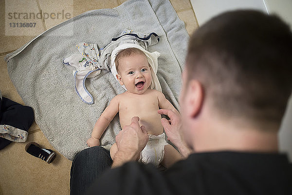 Porträt eines Jungen ohne Hemd  der zu Hause in einem Kinderbett sitzt