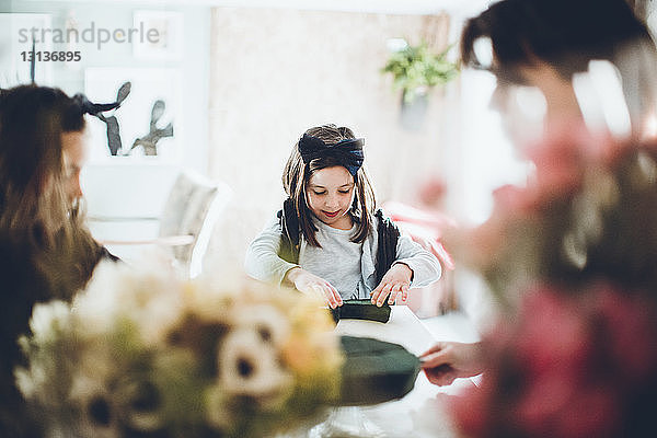 Mädchen hält Blumenschaum im Blumenladen