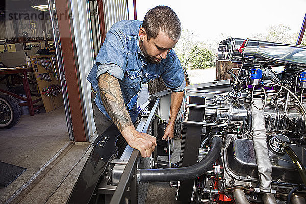Mechaniker repariert Motor in Autowerkstatt