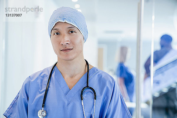 Porträt eines selbstbewussten Chirurgen mit chirurgischer Kappe im Krankenhaus