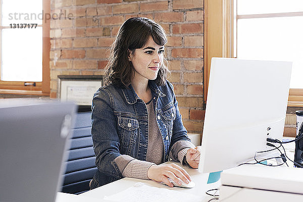 Geschäftsfrau  die einen Desktop-Computer benutzt  während sie im Büro arbeitet