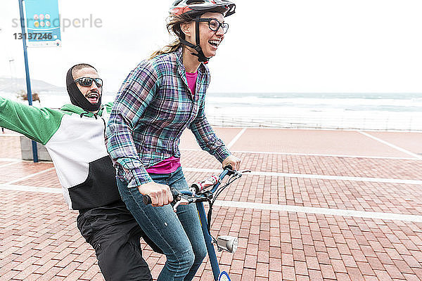 Freunde genießen Fahrradfahren auf der Promenade