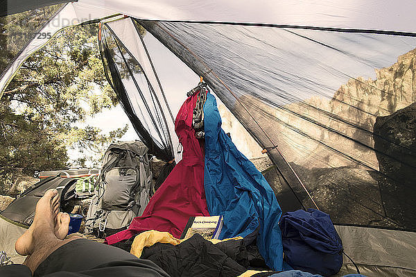 Niedriger Teil des Mannes entspannt sich im Zelt