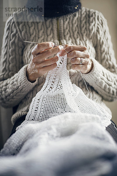 Mittelteil einer Frau  die zu Hause strickt