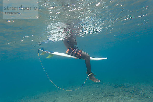 Niedriger Anteil von Menschen  die auf den Malediven im Meer surfen