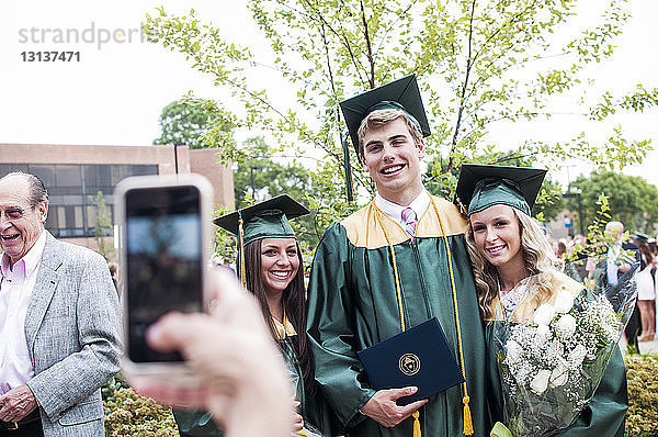 Ausschnitt einer Person  die Studenten bei der Abschlussfeier fotografiert