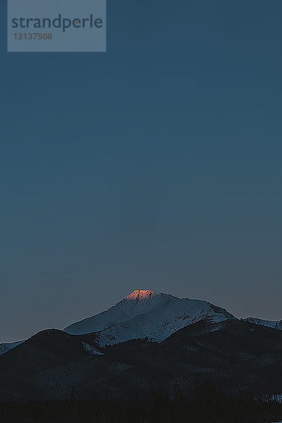 Majestätischer Blick auf schneebedeckten Berg gegen die Dämmerung