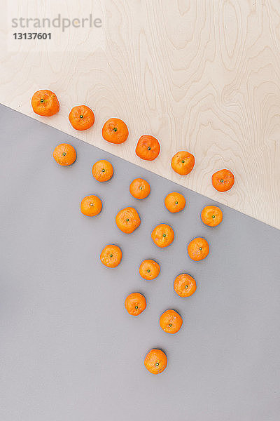 Draufsicht auf Orangen  die in Dreiecksform auf dem Tisch angeordnet sind