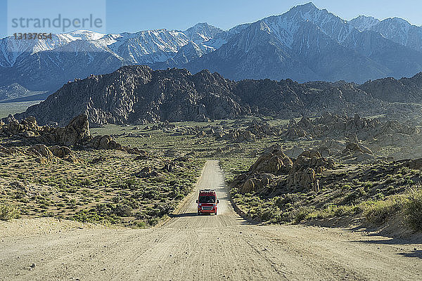 Fahrzeug auf unbefestigter Straße gegen Alabama Hills