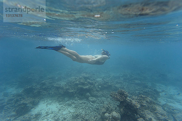Frau trägt Bikini beim Unterwasserschwimmen