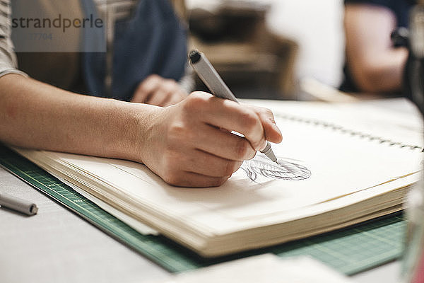 Mitschnitt einer Künstlerin beim Zeichnen auf Buch im Workshop