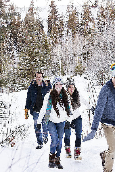 Glückliche Familie beim Spaziergang auf verschneitem Feld