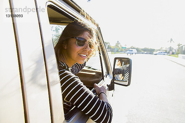 Porträt einer glücklichen Frau im Mini-Van auf der Strasse