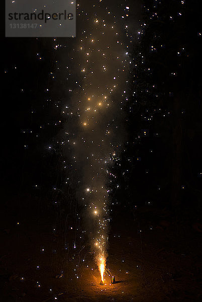 Hochwinkelaufnahme von Feuerwerkskörpern  die nachts während Diwali auf der Straße brennen
