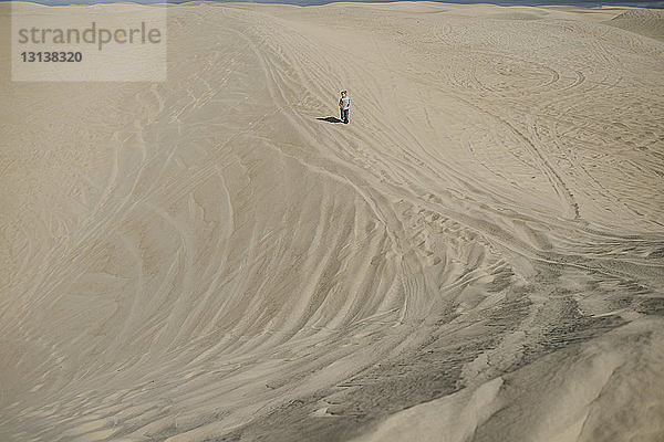 Fernansicht eines Jungen  der am Strand auf Sand läuft