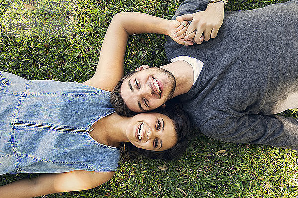 Portrait eines glücklichen Paares im Gras liegend