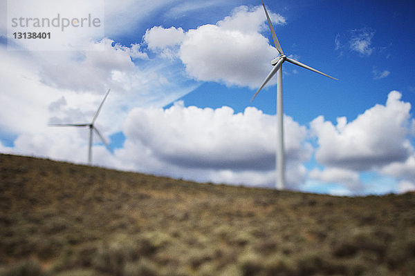 Windturbinen auf dem Feld gegen bewölkten Himmel