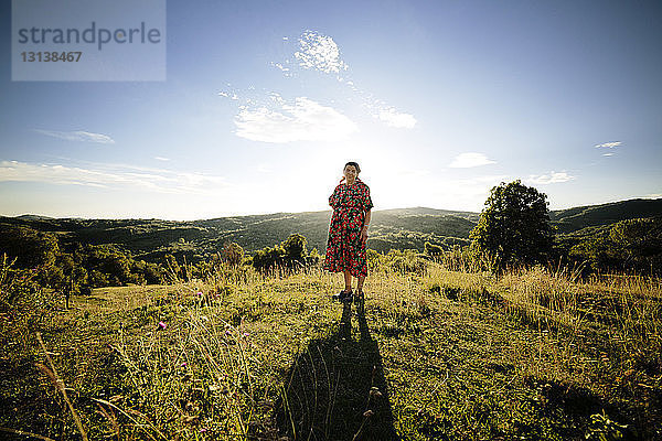 Porträt einer Frau  die auf einem Grasfeld gegen den Himmel steht
