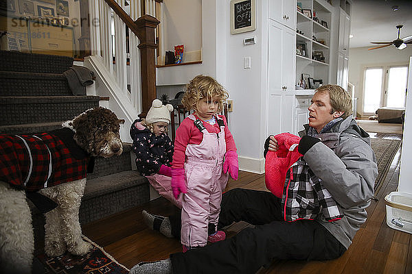 Vater mit Töchtern zu Hause auf dem Boden sitzend