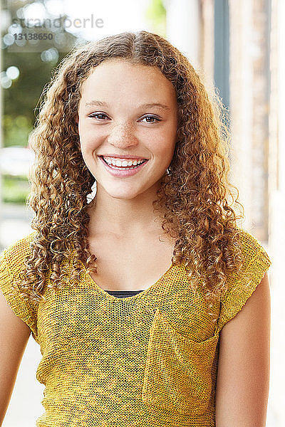 Porträt einer glücklichen Teenagerin im Freien stehend
