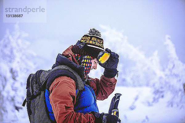 Seitenansicht eines Mannes bei der Vorbereitung zum Skifahren