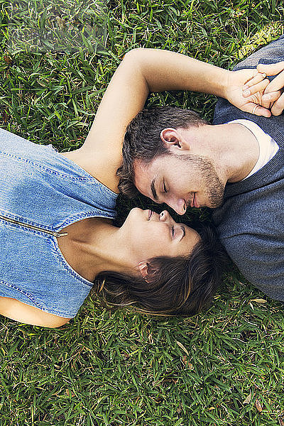 Draufsicht auf das auf Gras liegende romantische Paar