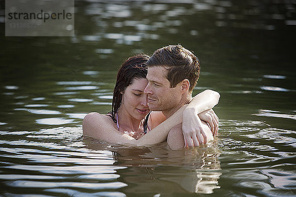 Paar umarmt sich  während es im See steht