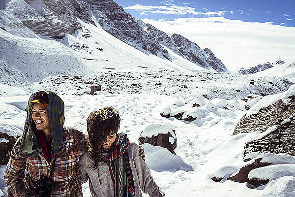 Glückliche Freunde stehen am schneebedeckten Berg