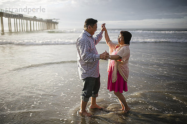 Seitenansicht eines Paares  das am Strand am Ufer tanzt