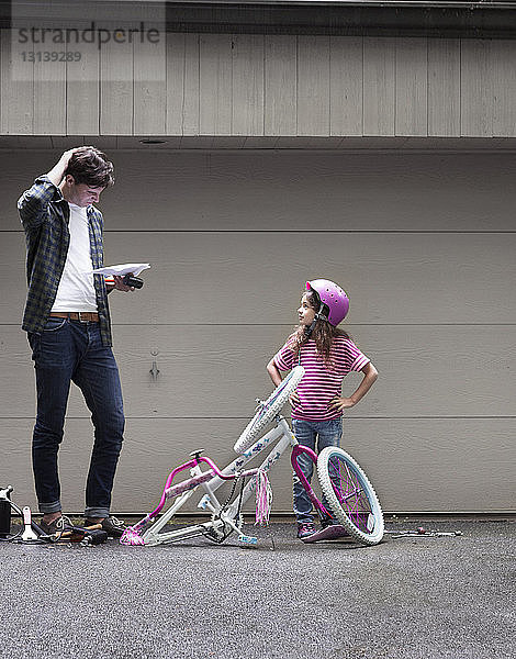 Vater und Tochter beim Fahrradzusammenbau